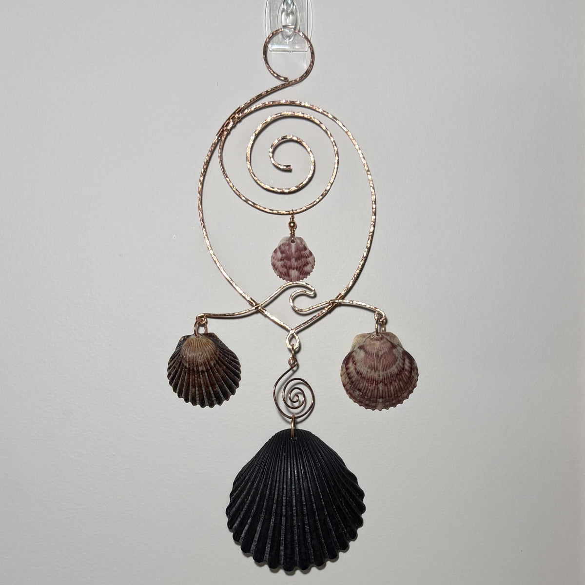 Front view of a shell and hammered copper wire wall/window display piece.